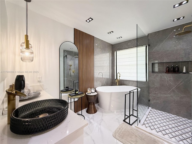 full bathroom featuring vanity, walk in shower, marble finish floor, and a freestanding bath
