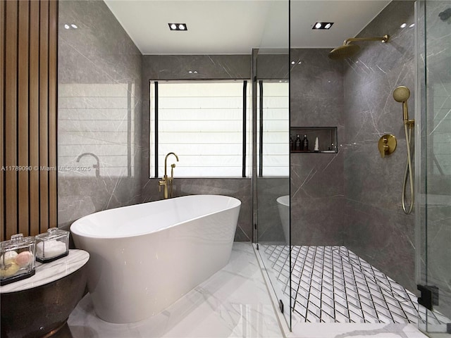 full bath with tile walls, a soaking tub, a shower stall, and marble finish floor