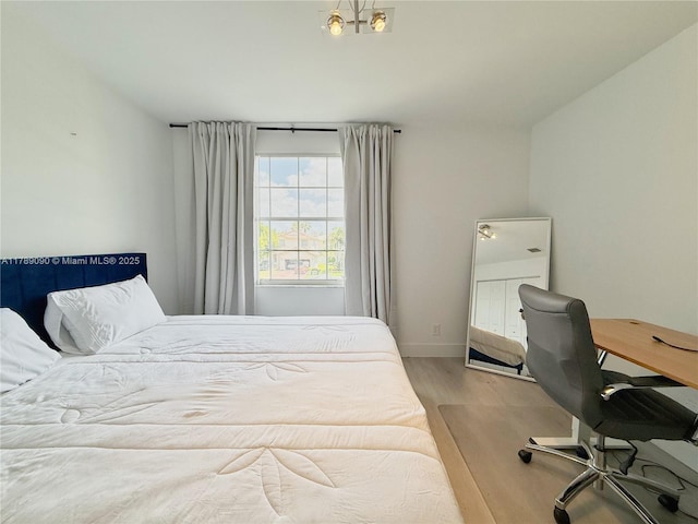 bedroom featuring baseboards and wood finished floors