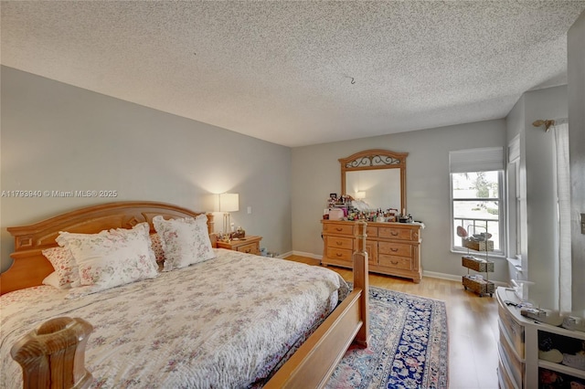12079 W Regal Ct W, Wellington, FL 33414 - bedroom with wood finished floors, a textured ceiling, and baseboards
