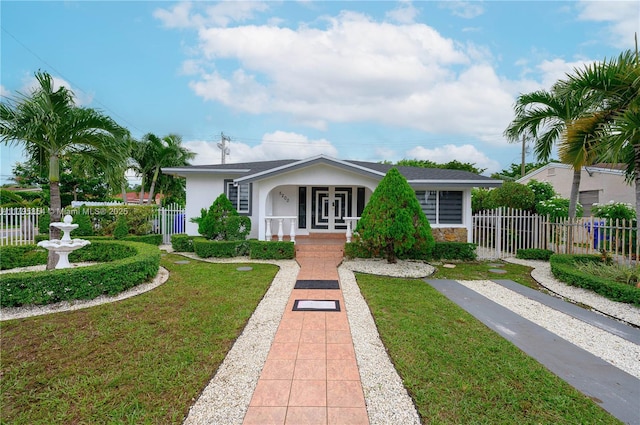 bungalow-style home featuring fence, stone siding, stucco siding, a front yard, and covered porch