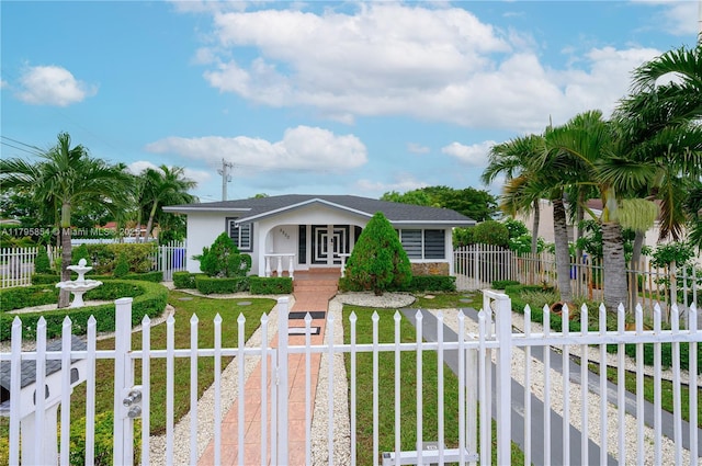 bungalow featuring a fenced front yard, stucco siding, a front lawn, and stone siding