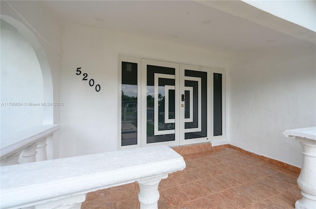 view of exterior entry with french doors and stucco siding