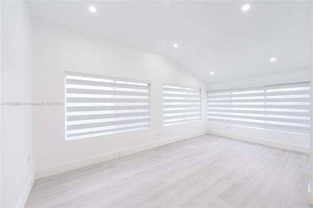 empty room with baseboards, recessed lighting, wood finished floors, and lofted ceiling