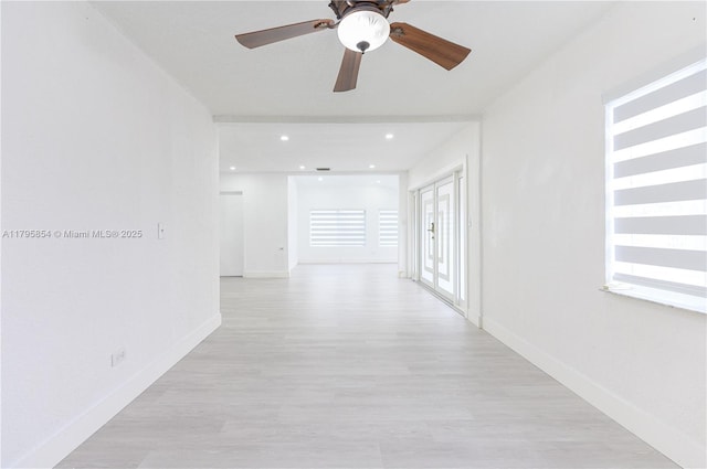 hall featuring baseboards and light wood-style flooring