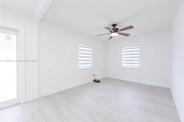 spare room featuring baseboards, a ceiling fan, and wood finished floors