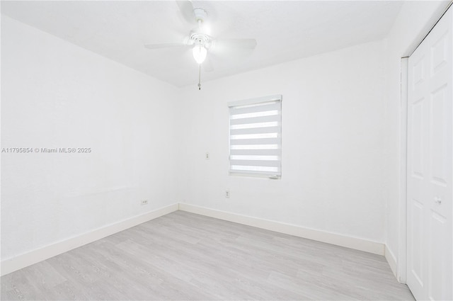 spare room with baseboards, a ceiling fan, and light wood-style flooring