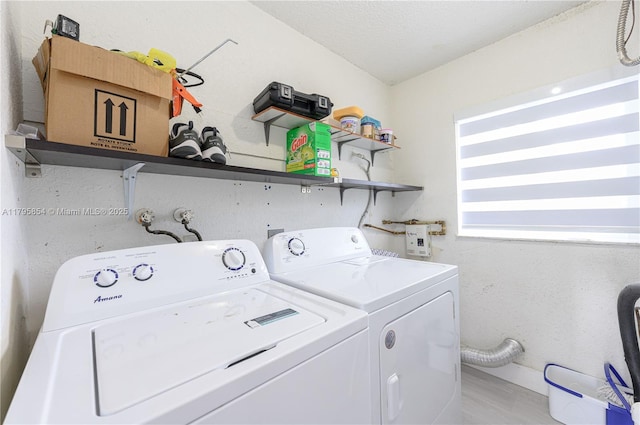 clothes washing area with laundry area, baseboards, washing machine and dryer, and light wood-type flooring