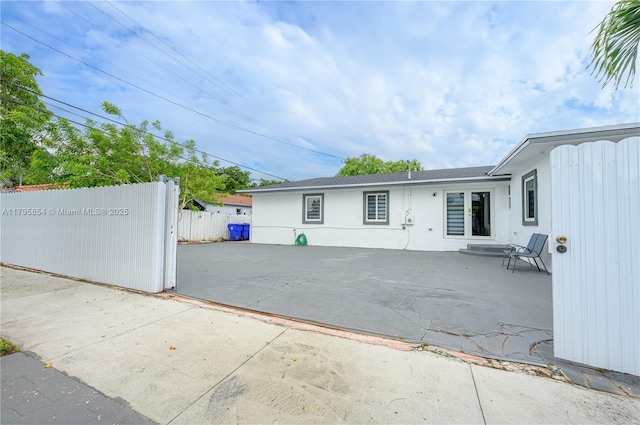back of property with stucco siding, a patio area, and fence