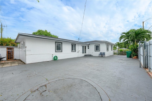 back of property featuring a patio, fence, and stucco siding
