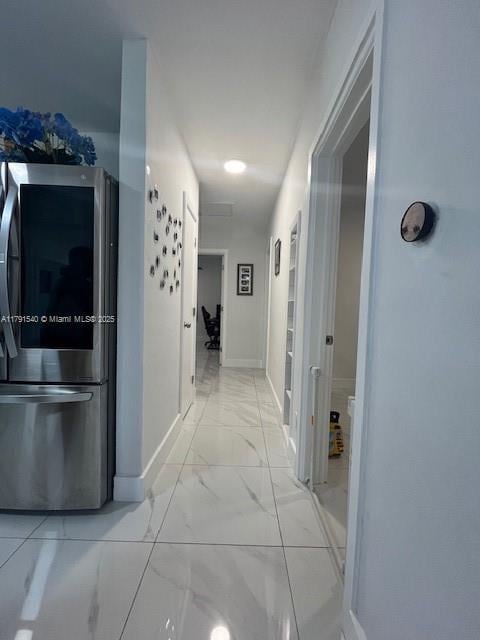 corridor featuring baseboards and marble finish floor