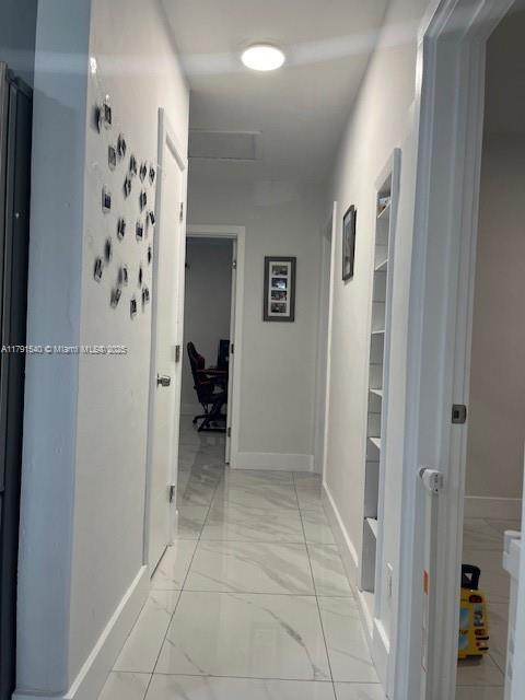 hall featuring baseboards and marble finish floor