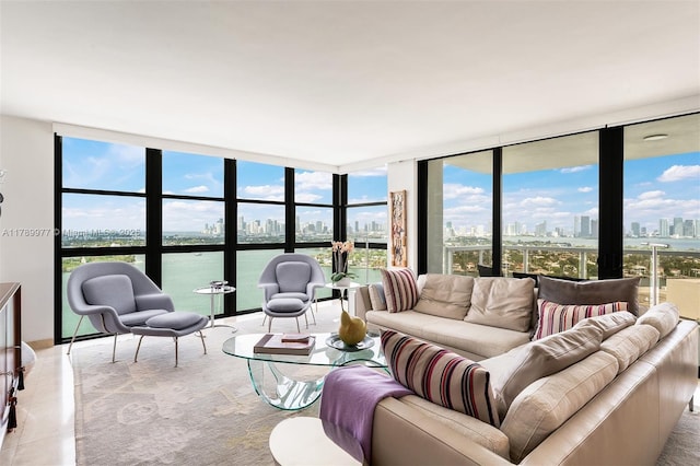 living area featuring a wall of windows, a skyline view, healthy amount of natural light, a water view, and tile patterned flooring