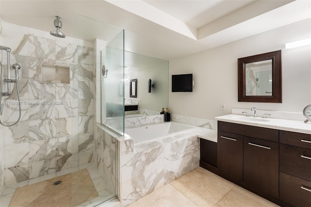 bathroom with a garden tub, vanity, and a tile shower