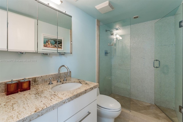 bathroom featuring a stall shower, toilet, and vanity