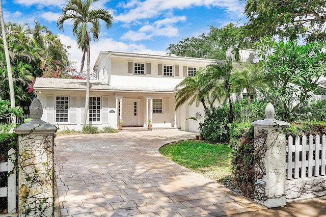 view of front of home with fence, stucco siding, and driveway