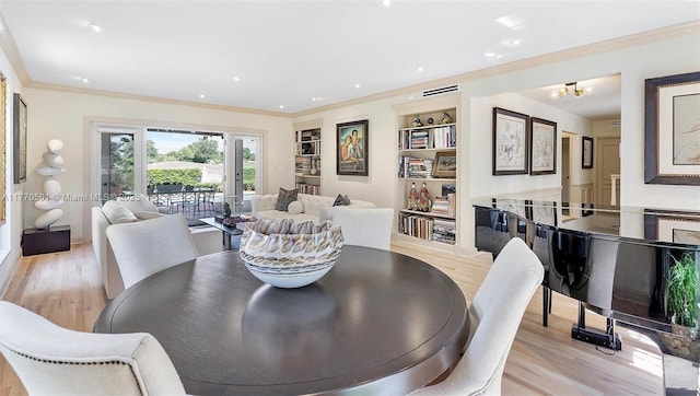 dining space featuring crown molding, recessed lighting, an inviting chandelier, and light wood-type flooring