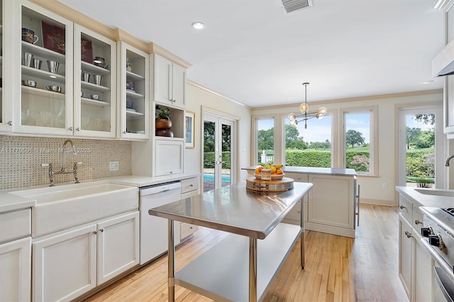 kitchen featuring gas stove, a sink, dishwasher, backsplash, and visible vents