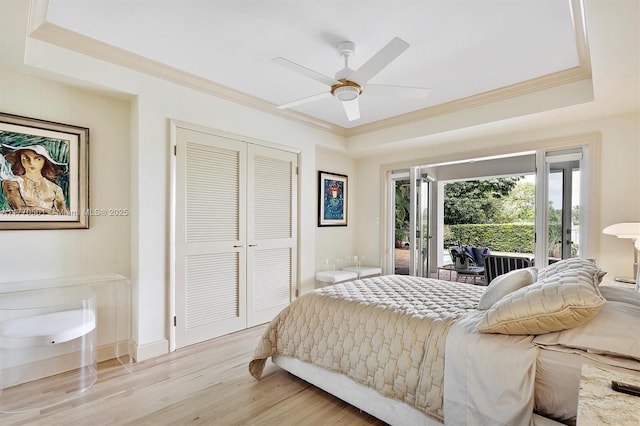 bedroom with ceiling fan, access to exterior, light wood-style flooring, ornamental molding, and a closet