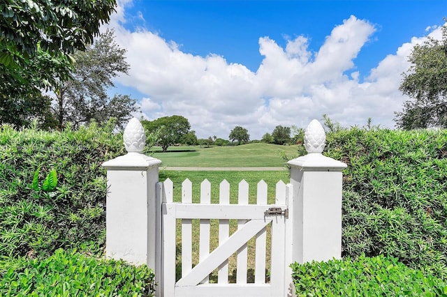 view of gate featuring a lawn and a fenced front yard