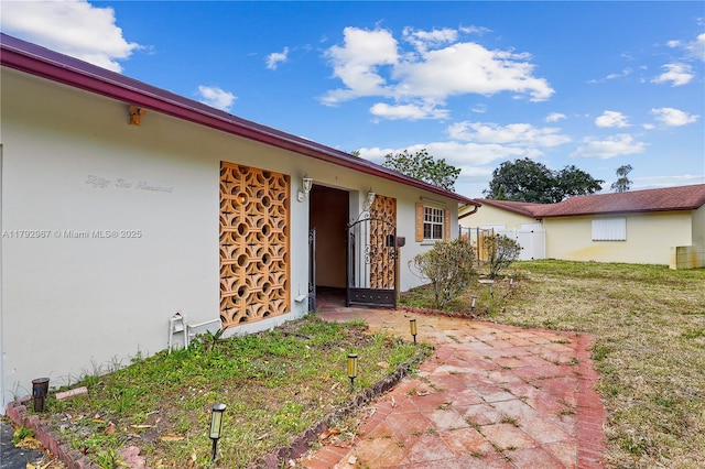entrance to property with stucco siding and fence
