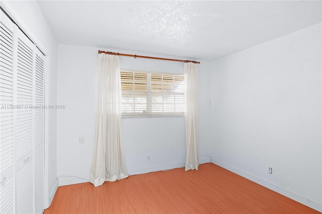 unfurnished room featuring baseboards and wood finished floors