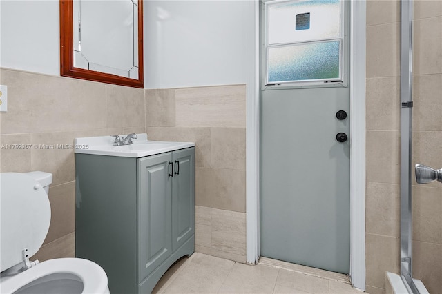 full bathroom featuring vanity, tile patterned flooring, toilet, tile walls, and a stall shower