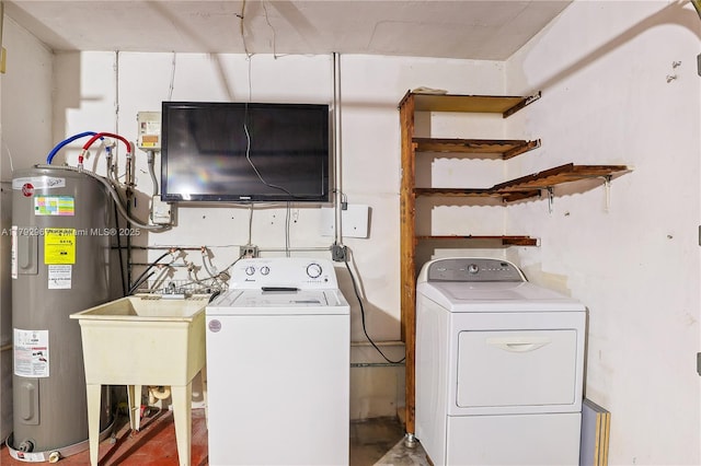 clothes washing area with a sink, separate washer and dryer, laundry area, and electric water heater