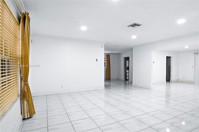 empty room with light tile patterned floors, ornamental molding, recessed lighting, and visible vents