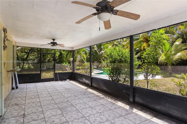 unfurnished sunroom featuring ceiling fan and a healthy amount of sunlight