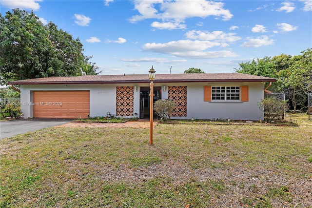 ranch-style home featuring stucco siding, an attached garage, a front lawn, and aphalt driveway