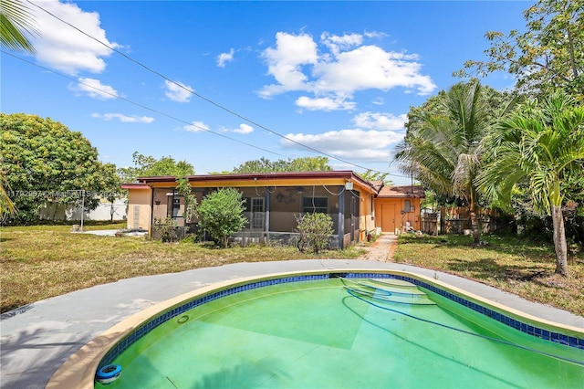 view of pool with a fenced in pool, a lawn, a sunroom, and fence