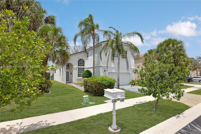 view of front of property with an attached garage, a front lawn, stucco siding, and driveway