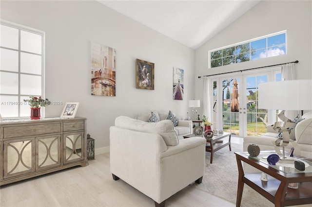 living room featuring baseboards, high vaulted ceiling, french doors, and light wood-type flooring