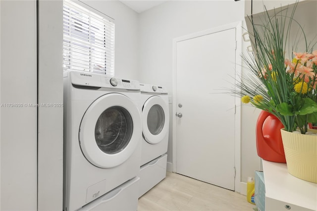 laundry room with laundry area, light wood-style flooring, and washing machine and clothes dryer