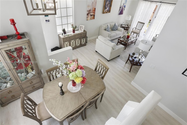 dining room with plenty of natural light, baseboards, wood finished floors, and a chandelier