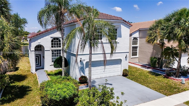 mediterranean / spanish house featuring an attached garage, a tile roof, and stucco siding