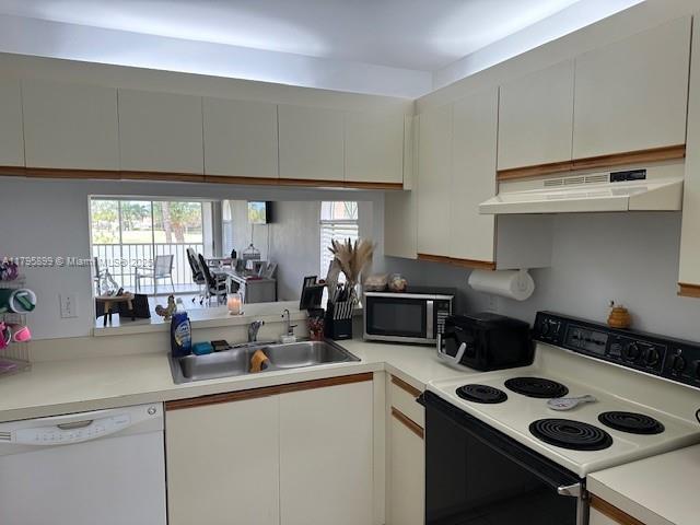 575 Augusta Blvd Unit 8, Naples, FL 34113 - kitchen with white cabinets, white dishwasher, electric range, a sink, and under cabinet range hood