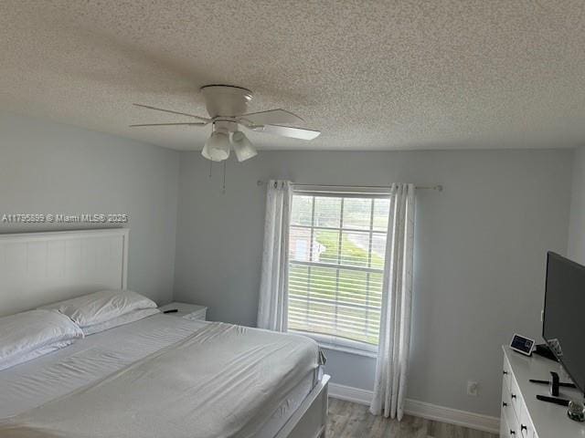 575 Augusta Blvd Unit 8, Naples, FL 34113 - bedroom with a textured ceiling, ceiling fan, baseboards, and light wood-type flooring