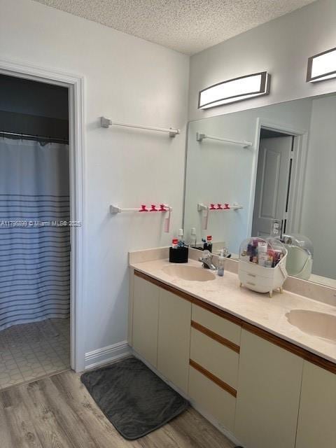 575 Augusta Blvd Unit 8, Naples, FL 34113 - full bathroom with a sink, a textured ceiling, double vanity, and wood finished floors