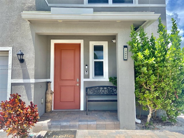 view of exterior entry featuring stucco siding