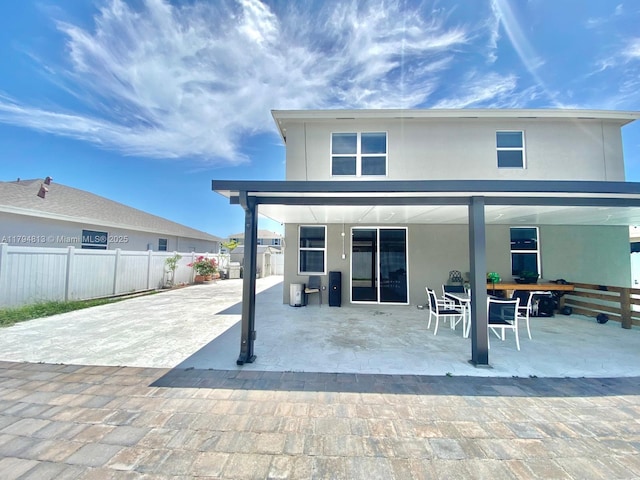 back of property featuring a patio, fence, outdoor dining space, and stucco siding