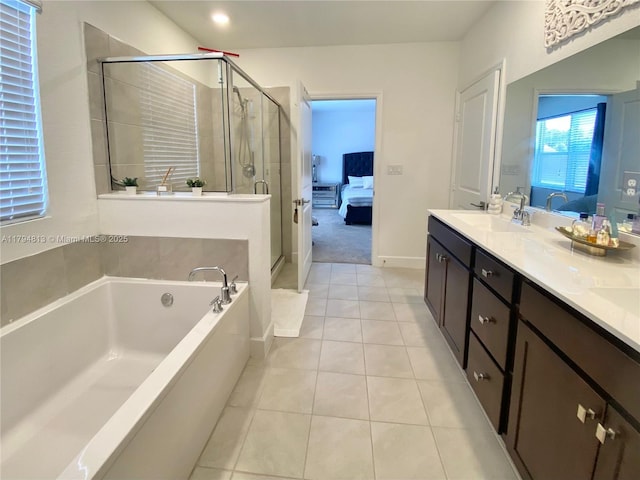 ensuite bathroom with connected bathroom, a sink, tile patterned flooring, a shower stall, and a bath