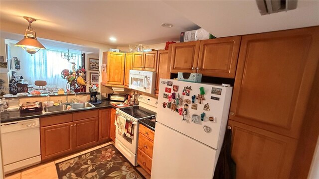 4330 Hillcrest Dr Unit 214, Hollywood, FL 33021 - kitchen with white appliances, a sink, dark countertops, brown cabinetry, and hanging light fixtures