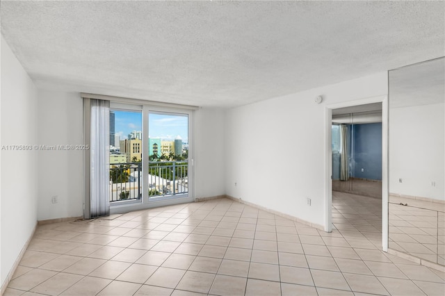 345 Ocean Dr Unit 904, Miami Beach, FL 33139 - empty room featuring a textured ceiling, a city view, and light tile patterned floors