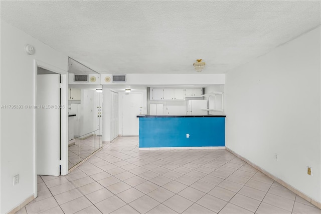 345 Ocean Dr Unit 904, Miami Beach, FL 33139 - kitchen featuring refrigerator, a peninsula, dark countertops, open shelves, and a textured ceiling