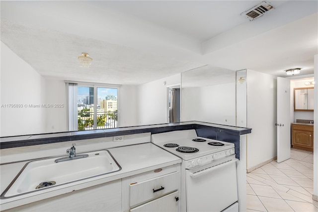 345 Ocean Dr Unit 904, Miami Beach, FL 33139 - kitchen featuring electric range, white cabinetry, light tile patterned flooring, and light countertops