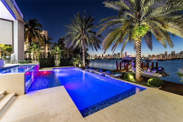 pool featuring a hot tub and a view of city lights