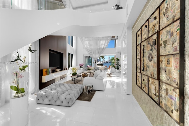 living room with light tile patterned flooring and a high ceiling