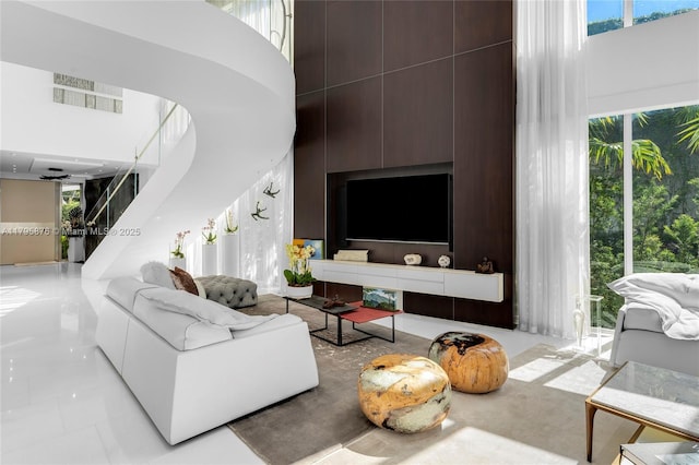 living room featuring plenty of natural light, visible vents, and a towering ceiling